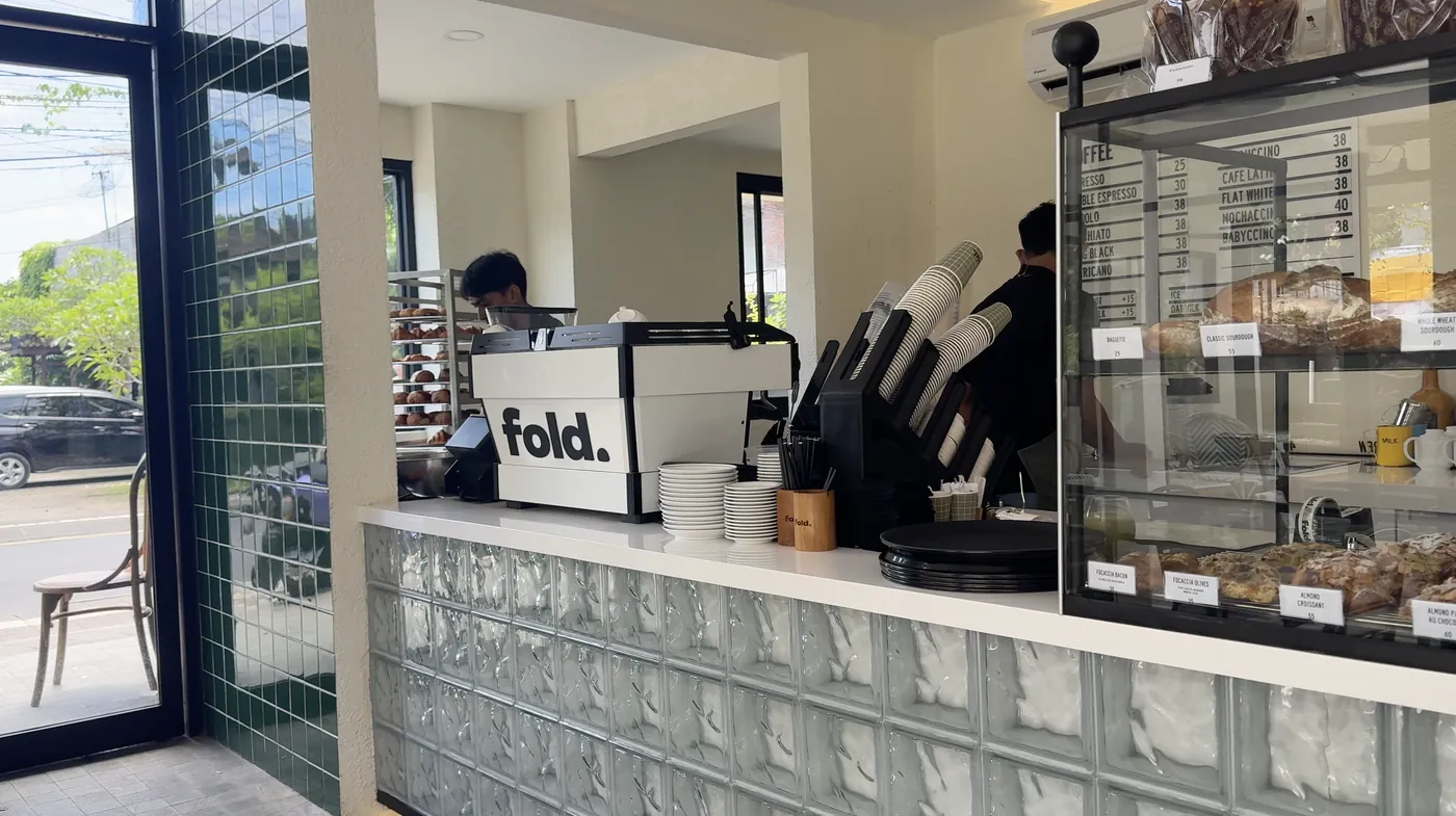A cafe counter with a coffee machine and a display of pastries