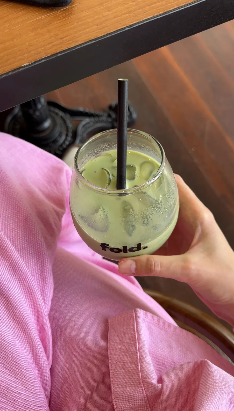 Me holding an iced matcha drink with a black straw