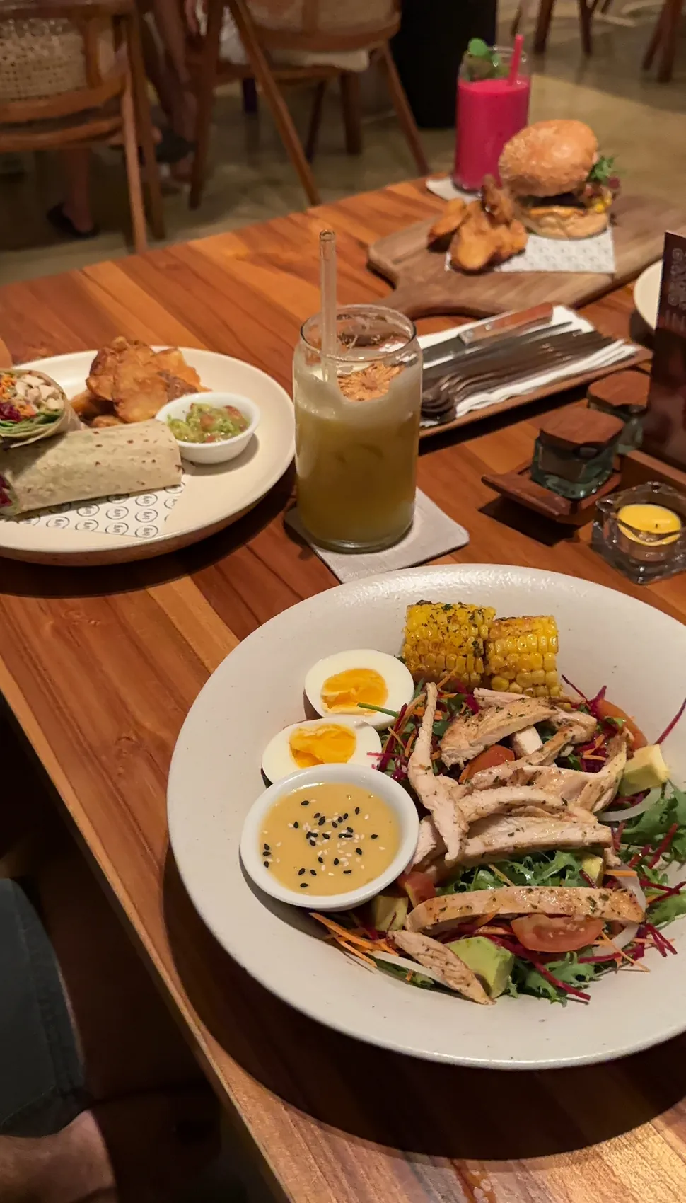 A table with a salad, a burger and drinks at Ivy