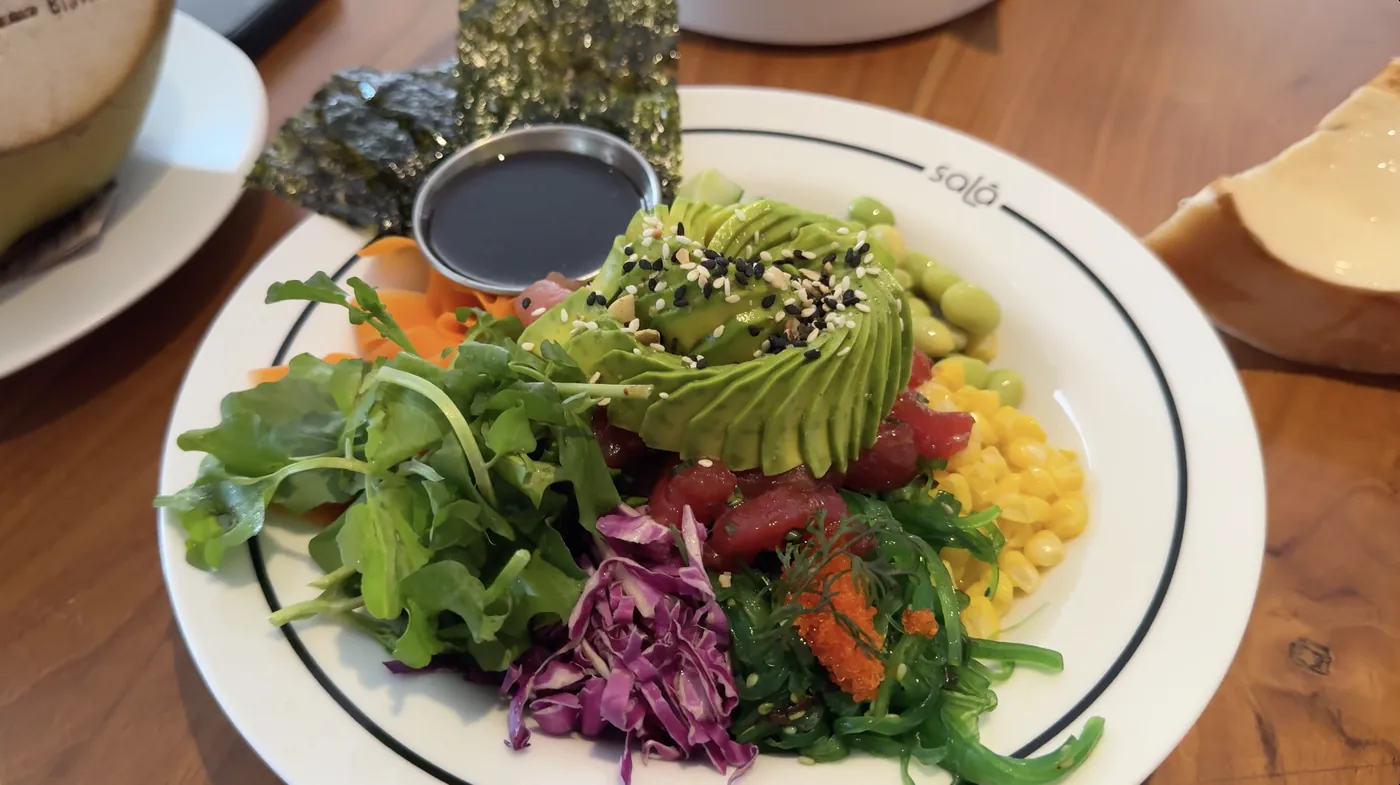 A colourful bowl with avocado, corn, seaweed and fresh greens