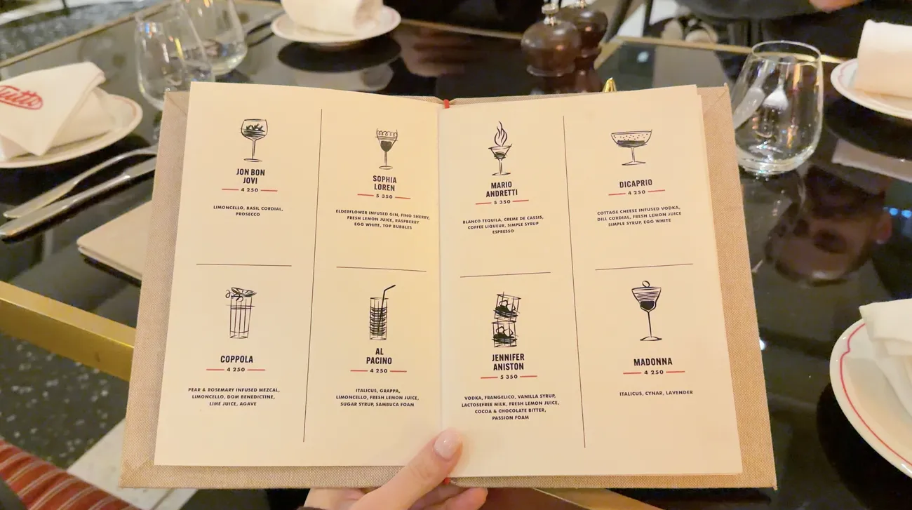 An open cocktail menu with small illustrations of drinks.