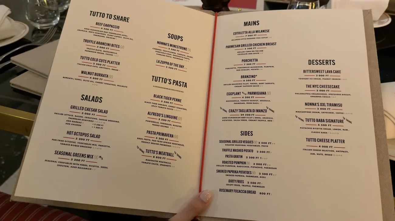 An open menu listing starters, pasta, mains and desserts.