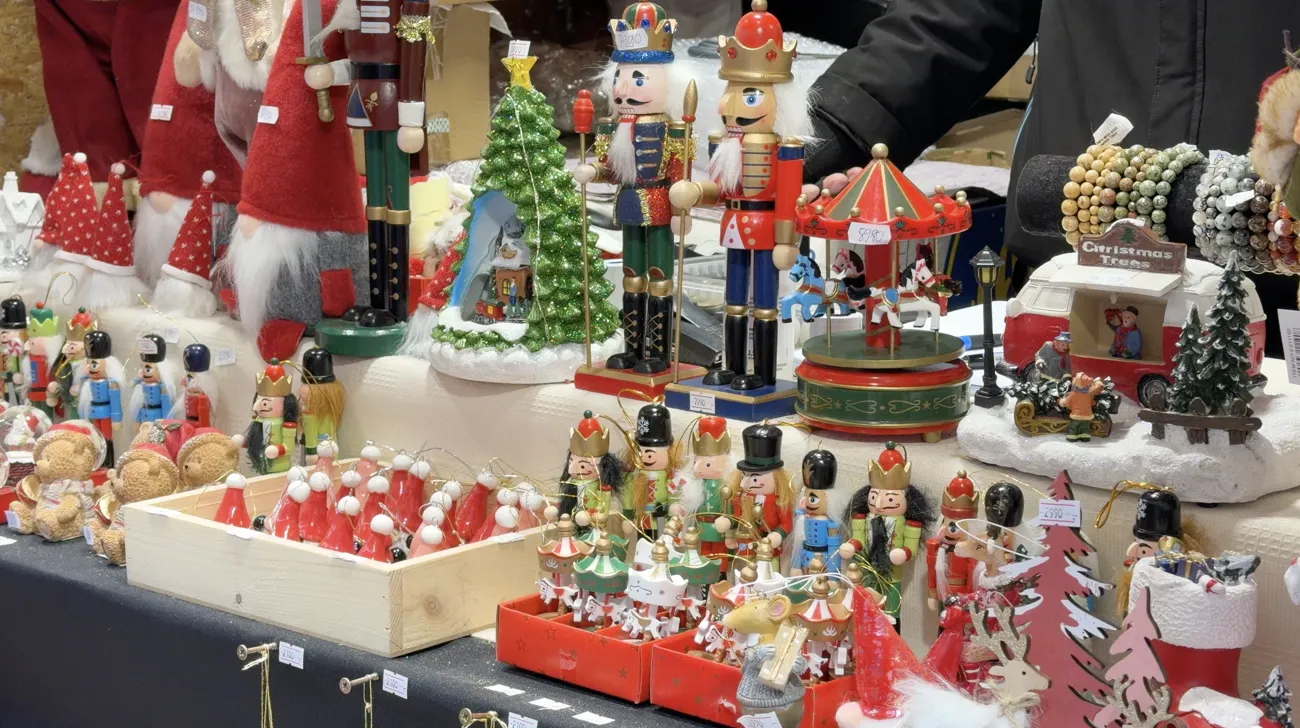 A market table covered with nutcrackers, small figures and Christmas decorations.