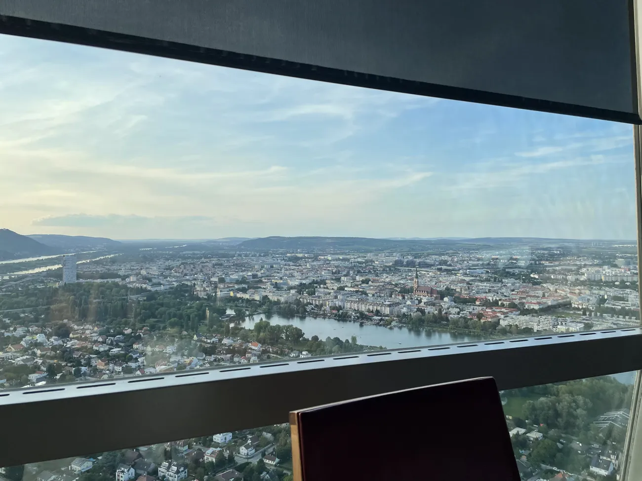 Vienna and water seen through the restaurant window, with a chair in the foreground.