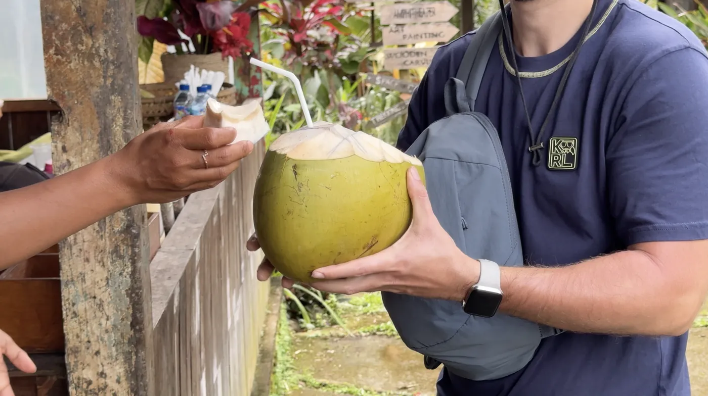 My husband holding a fresh coconut with a straw