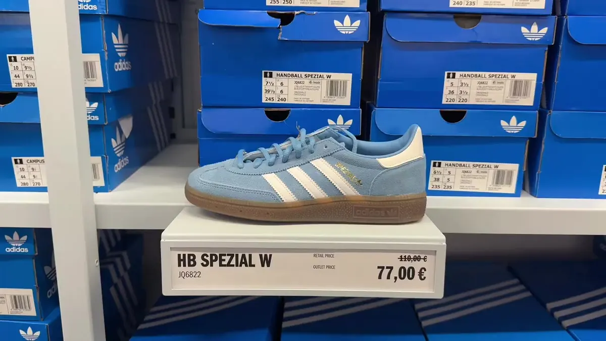 Blue adidas Handball Spezial on a display marked outlet €77 and retail €110.