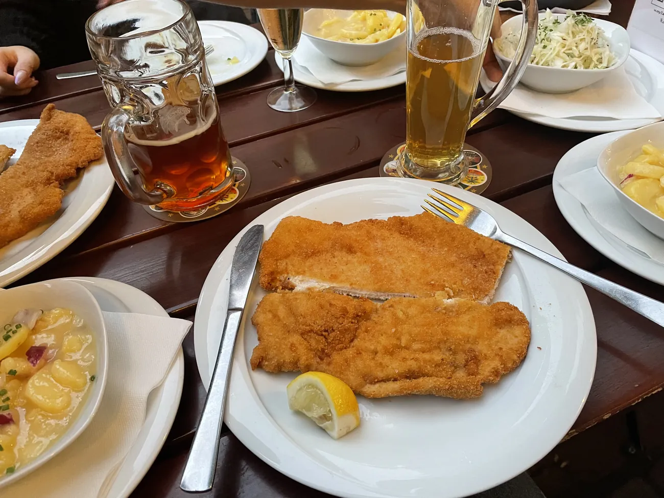 Breaded schnitzel with lemon, potato salad and beer at 7Stern Bräu