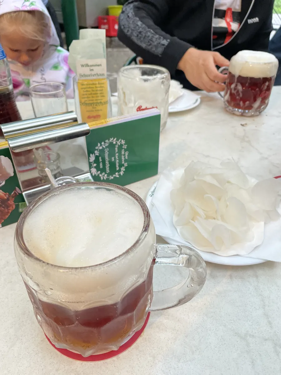 Beer mugs and pale sliced sides on a table at Schweizerhaus
